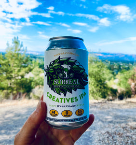 Can of Surreal Non-Alcoholic Creatives West Coast IPA. 44 Calories, zero sugar, 8.5 carbs. With a trail, forest setting.