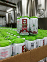Load image into Gallery viewer, Multiple cans of Surreal Non-Alcoholic Beer in a brewery setting. 
