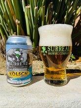 Load image into Gallery viewer, Can of Surreal Non-Alcoholic Kolsch Style. 17 Calories, Zero Sugar, 2.8 calories.  Next to a poured out light golden glass of Surreal Non-Alcoholic Kolsch with a light cream foamy head. 
